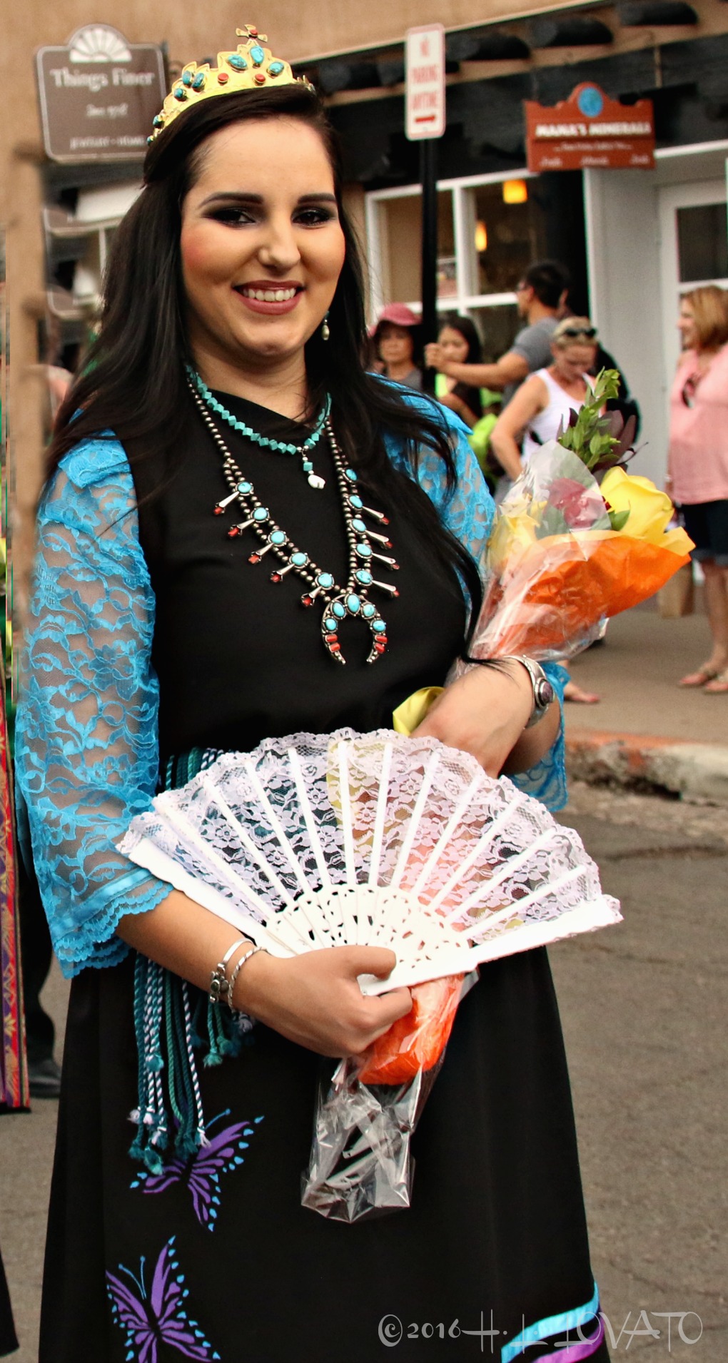 Woman dressed in traditional attire holding a lace fan